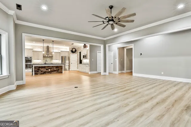 a view of a livingroom with furniture a ceiling fan and wooden floor