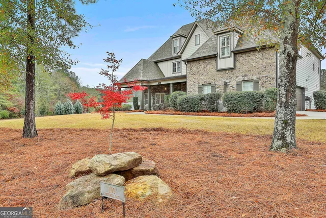 a view of a house with backyard and trees
