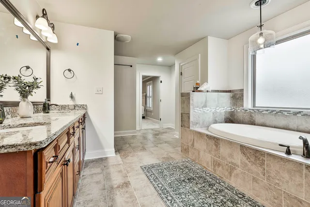 a bed sitting in a spacious bedroom next to a window