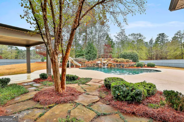 a view of a swimming pool with a yard and plants