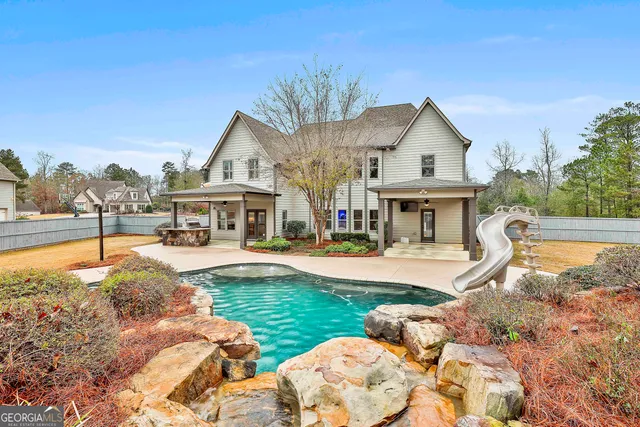 a view of a house with pool and sitting area