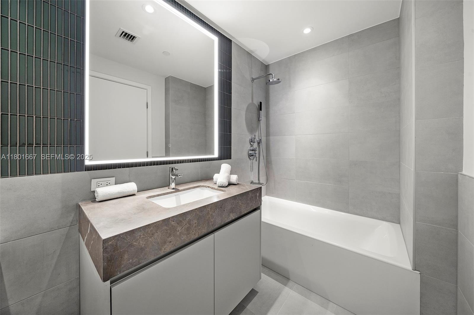 500 Alton Road, Unit 3602 Miami Beach, FL 33139 - Photo 21 of 33 a bathroom with a bathtub sink vanity and mirror