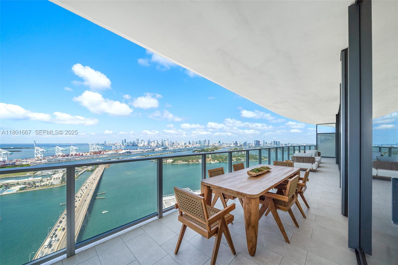 500 Alton Road, Unit 3602 Miami Beach, FL 33139 - Photo 5 of 33 a view of a terrace with furniture and a floor to ceiling window