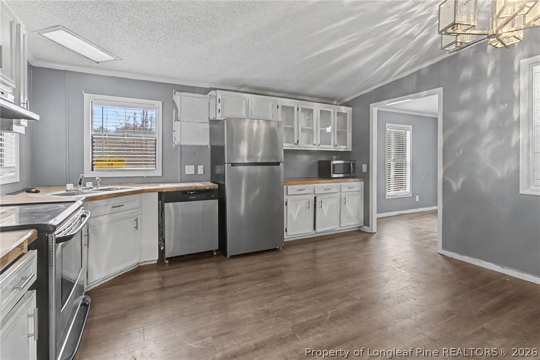 1512 Seabrook School Road Fayetteville, NC 28312 - Photo 22 of 30 a kitchen with white cabinets and white appliances