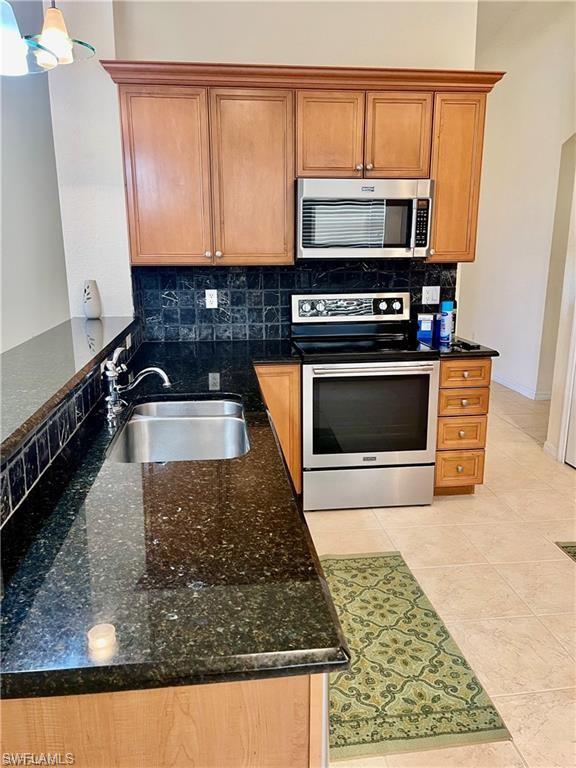 2132 Par Drive Naples, FL 34120 - Photo 5 of 15 a kitchen with stainless steel appliances granite countertop a sink stove and microwave