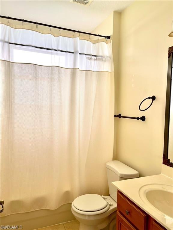 2132 Par Drive Naples, FL 34120 - Photo 9 of 15 a white toilet sitting next to a shower curtain