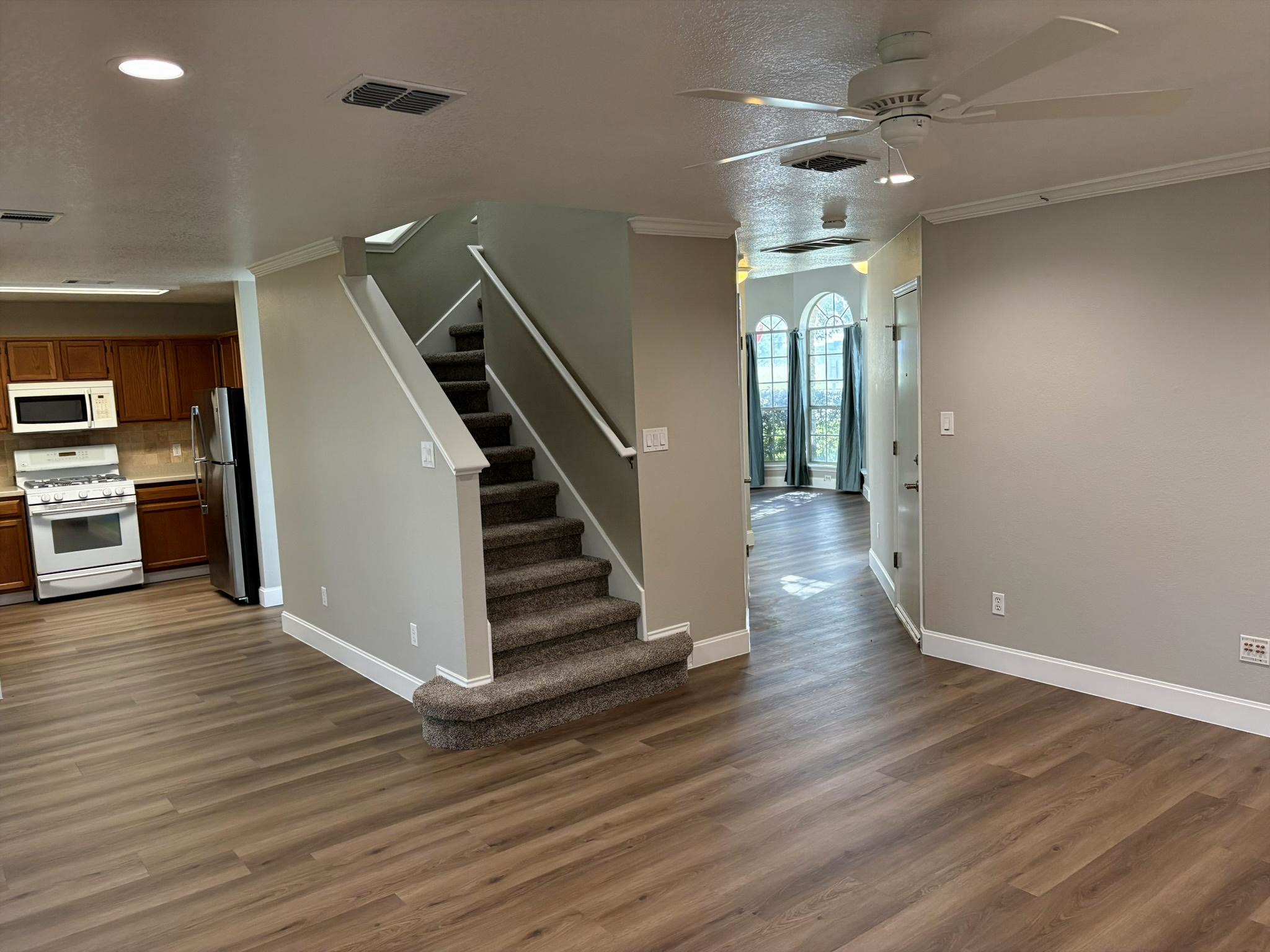 14707 Single Trace Austin, TX 78728 - Photo 11 of 17 Laminate flooring throughout connects the kitchen and living areas, offering a seamless flow.
