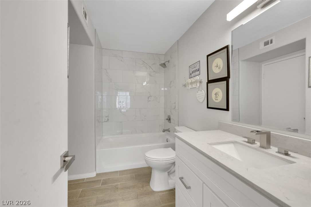 698 South Racetrack Road, Unit 1614 Henderson, NV 89015 - Photo 12 of 35 Modern bathroom featuring white subway tile shower, sleek vanity, and light wood-look flooring.