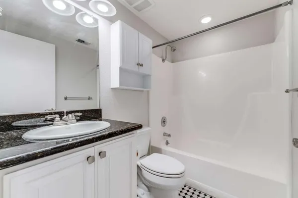 a bathroom with a granite countertop sink toilet and shower