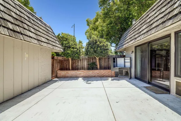 a view of a house with sitting area and covered with trees