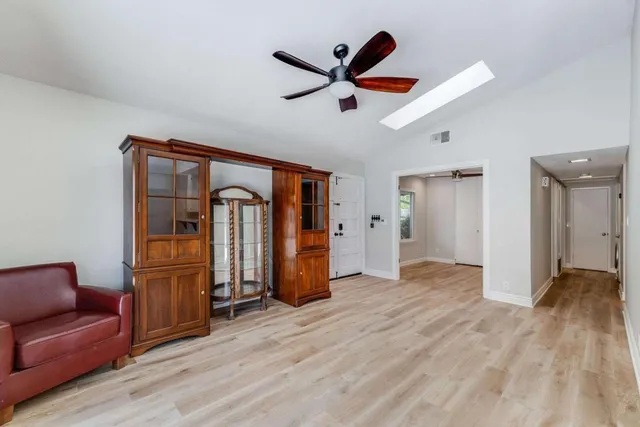 a view of empty room with wooden floor and ceiling fan