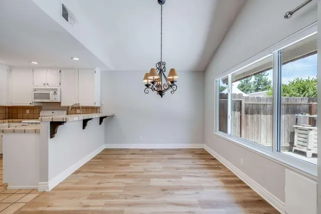 a view of a kitchen with wooden floor and a window