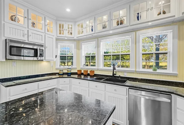 a kitchen with stainless steel appliances granite countertop a sink a microwave and cabinets