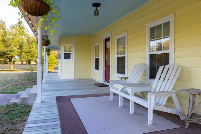 a view of a patio with table and chairs with wooden floor and fence