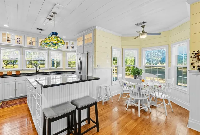 a view of a dining room with furniture a chandelier and wooden floor