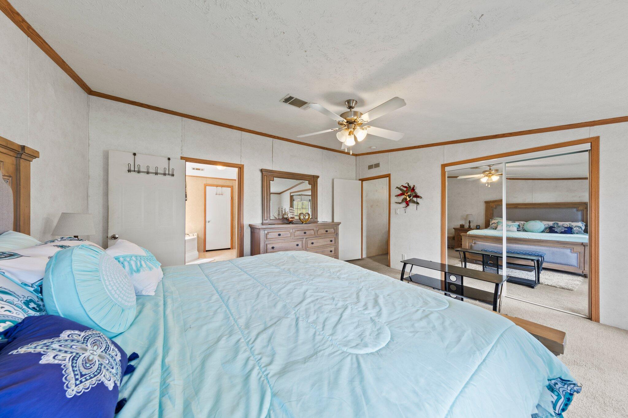 3943 Bambi Road Crestview, FL 32539 - Photo 8 of 36 a bedroom with a bed and a large mirror with window