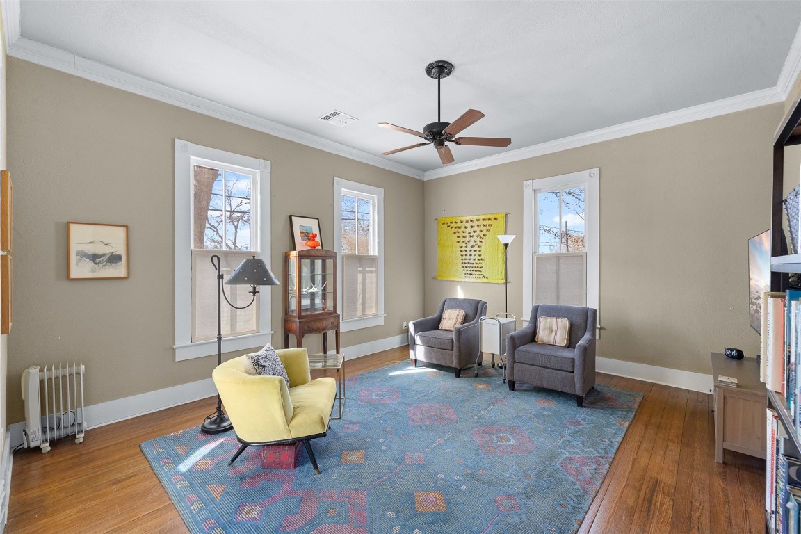 660 North Main Street La Grange, TX 78945 - Photo 8 of 24 Living area featuring crown molding, hardwood / wood-style flooring, radiator heating unit, a ceiling fan, and healthy amount of natural light