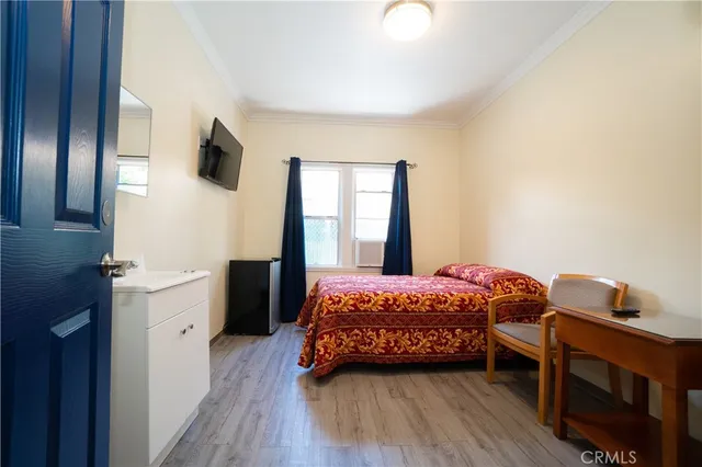 a bedroom with a bed and wooden floor