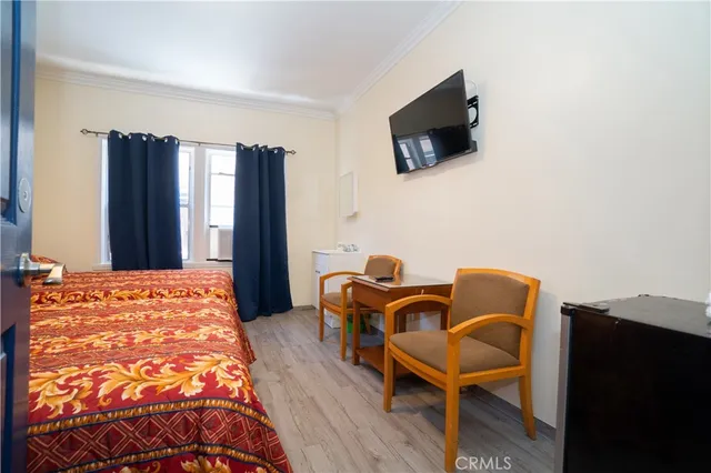 a bedroom with furniture and a flat screen tv