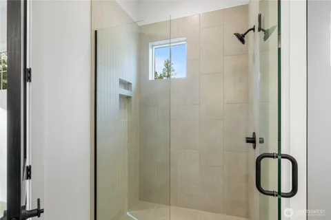 a bathroom with a granite countertop shower and a mirror