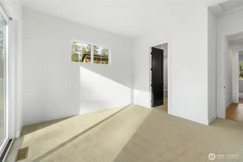 a view of a big room with windows and a ceiling fan