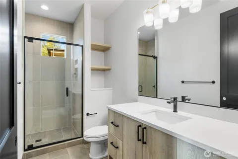 a bathroom with a sink a toilet and shower