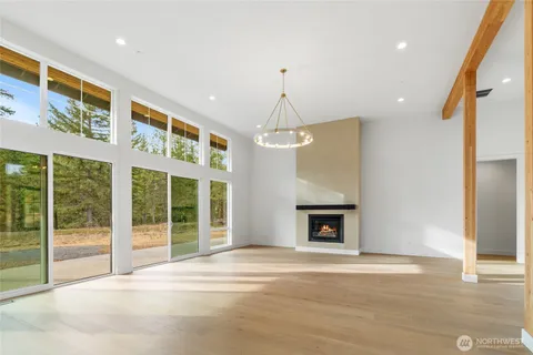 a view of an empty room with a fireplace and a window