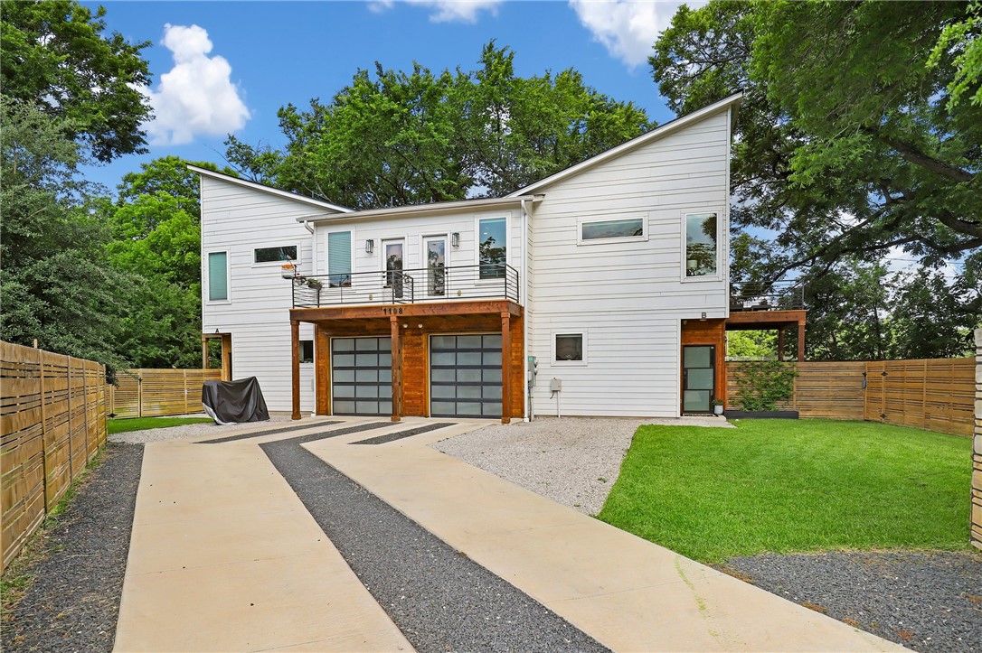 a front view of house with yard and trees in the background