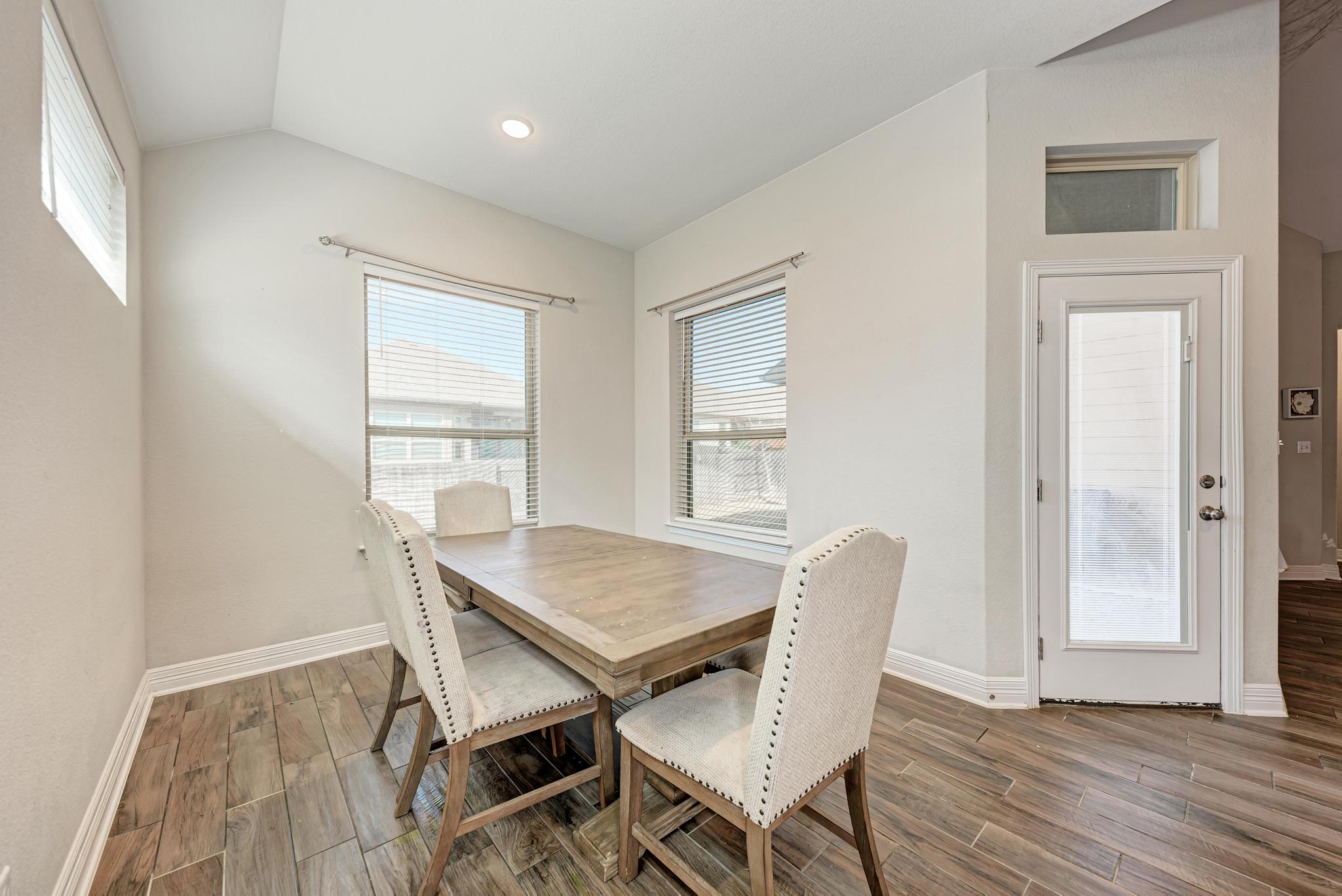 198 Rough Leaf Drive Buda, TX 78610 - Photo 17 of 38 Dining room featuring wood tiled floors, healthy amount of natural light, lofted ceiling, and recessed lighting