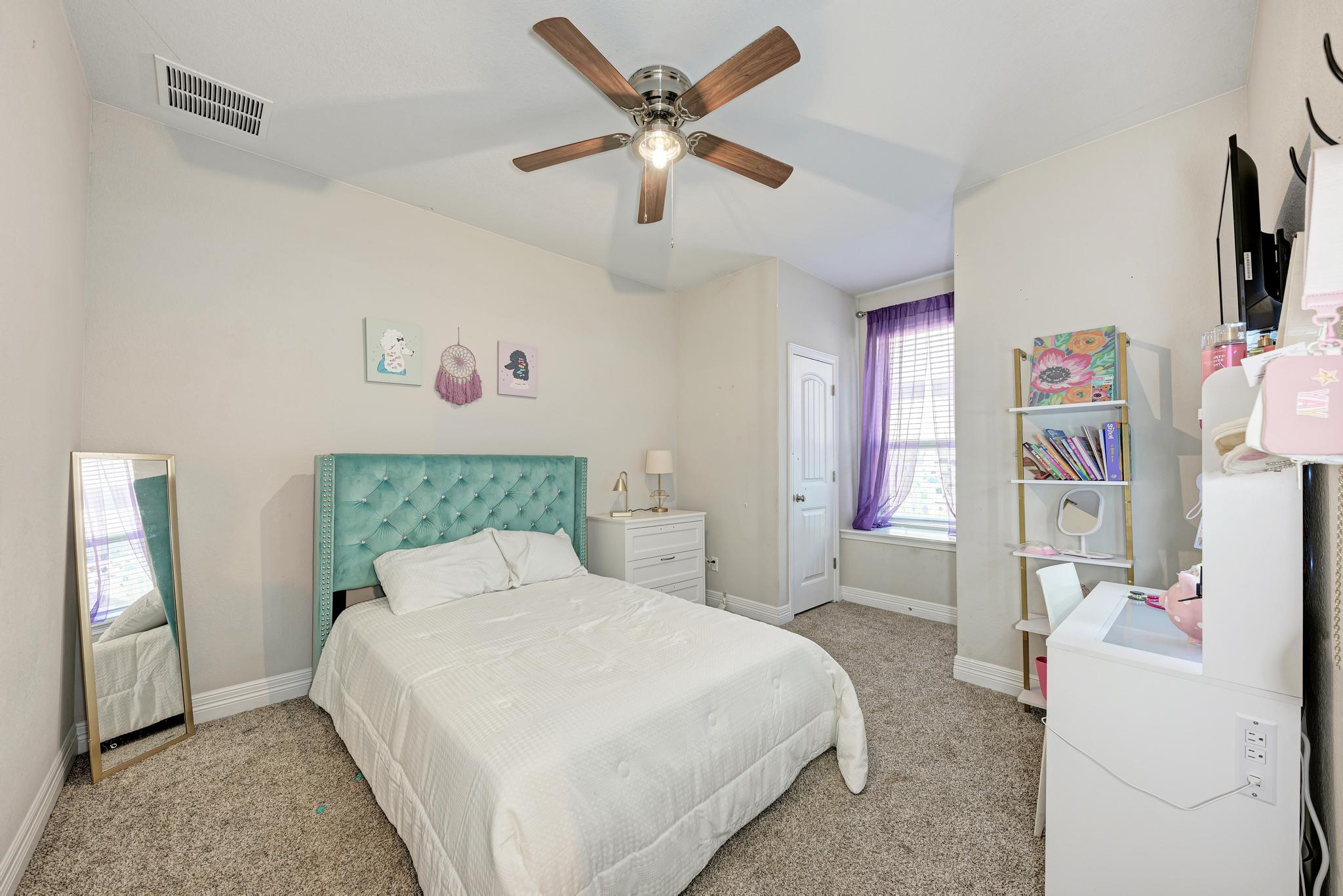 198 Rough Leaf Drive Buda, TX 78610 - Photo 21 of 38 Bedroom with light carpet and ceiling fan