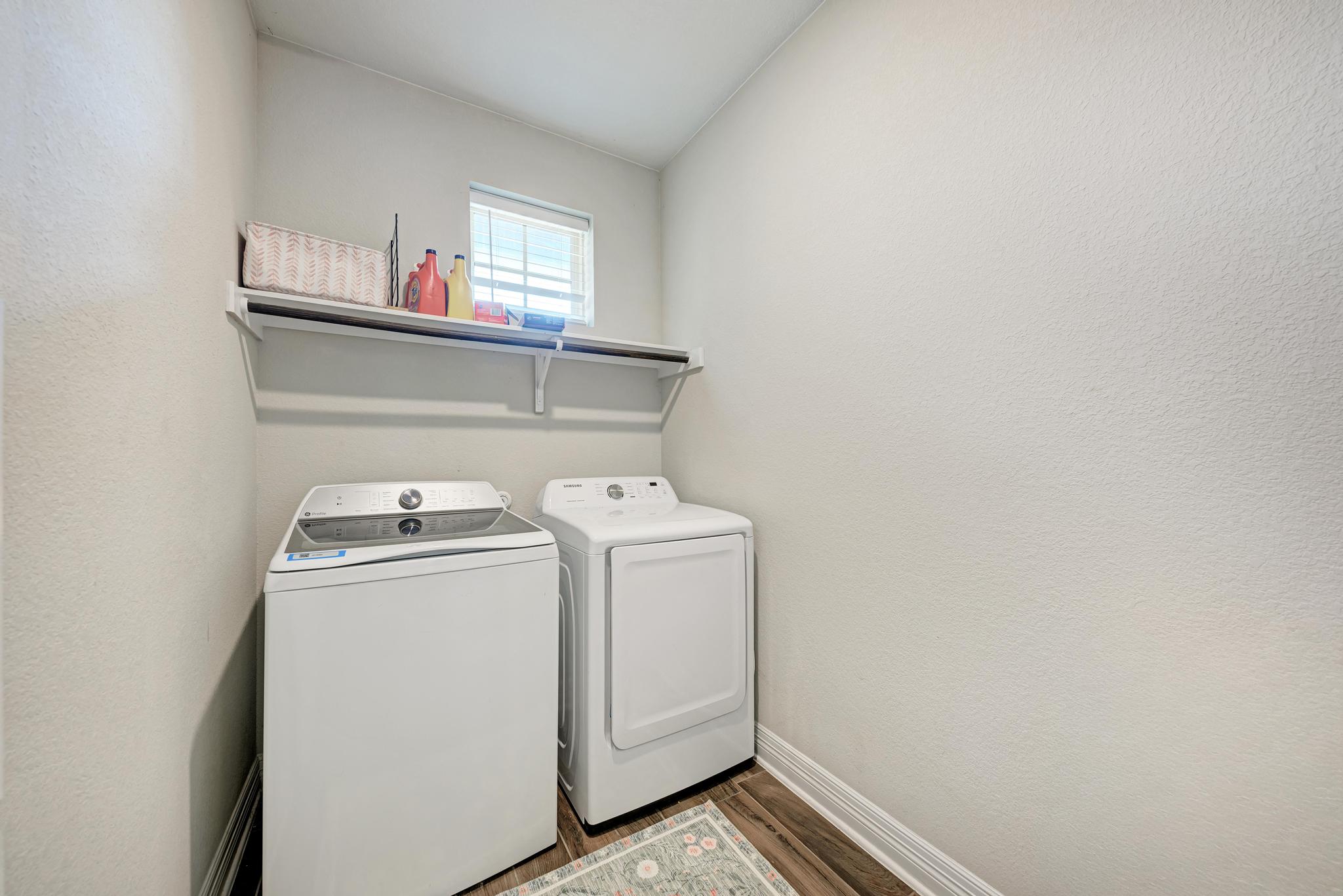 198 Rough Leaf Drive Buda, TX 78610 - Photo 27 of 38 Laundry room featuring a textured wall, independent washer and dryer, dark wood finished floors, and lofted ceiling