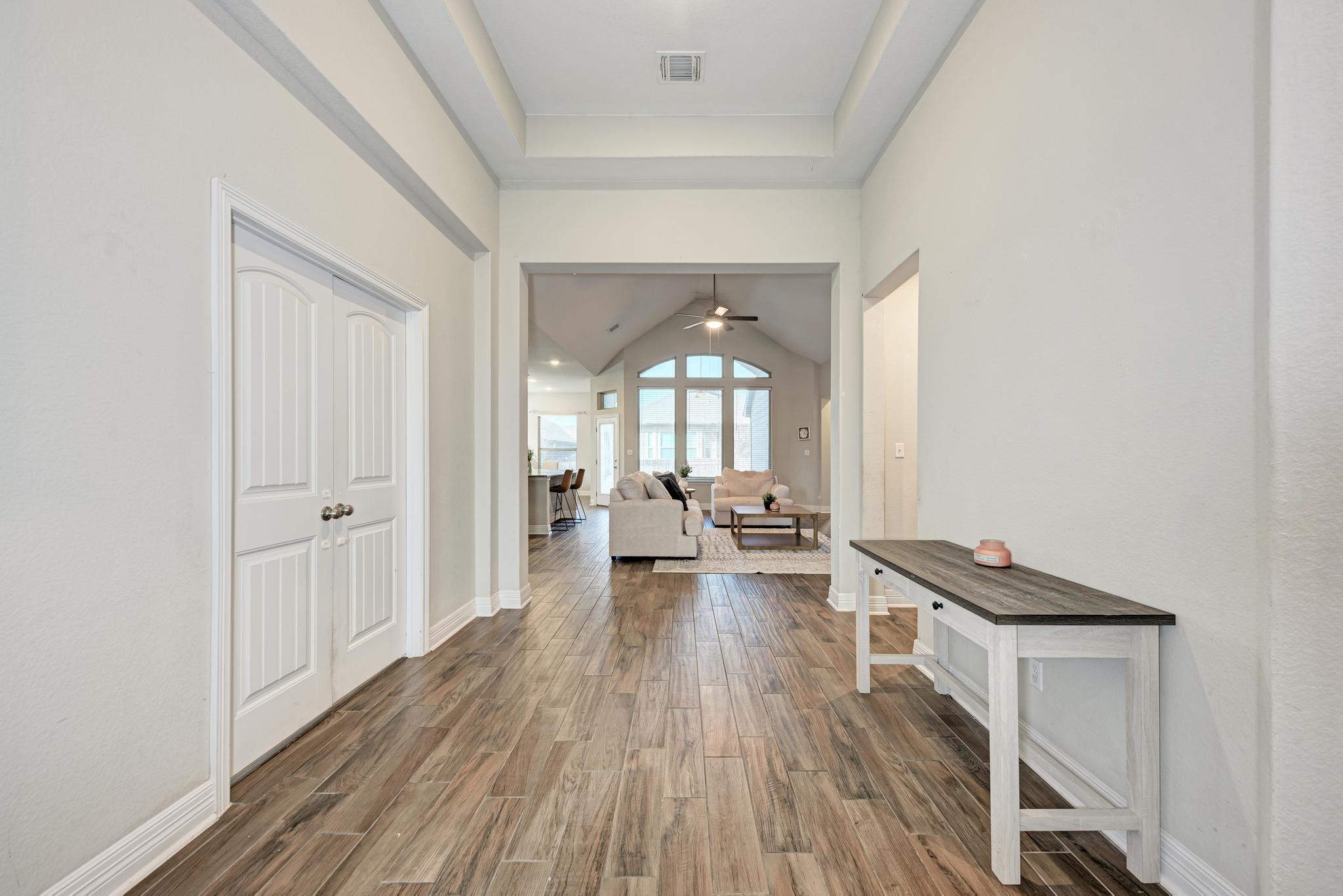 198 Rough Leaf Drive Buda, TX 78610 - Photo 7 of 38 Hallway featuring dark wood finished floors, a raised ceiling, and lofted ceiling
