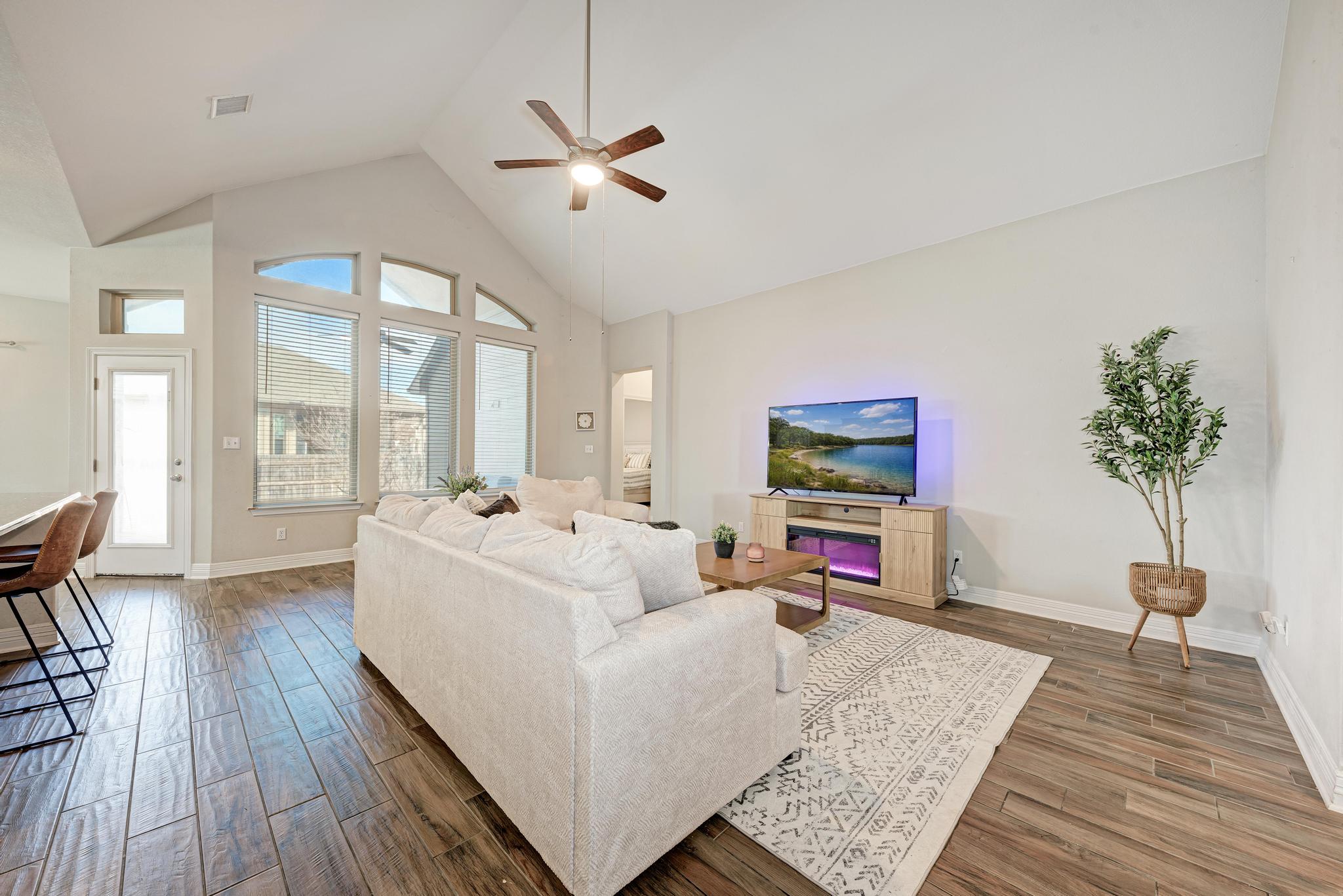 198 Rough Leaf Drive Buda, TX 78610 - Photo 8 of 38 Living area featuring a high ceiling, wood finish floors, and a ceiling fan