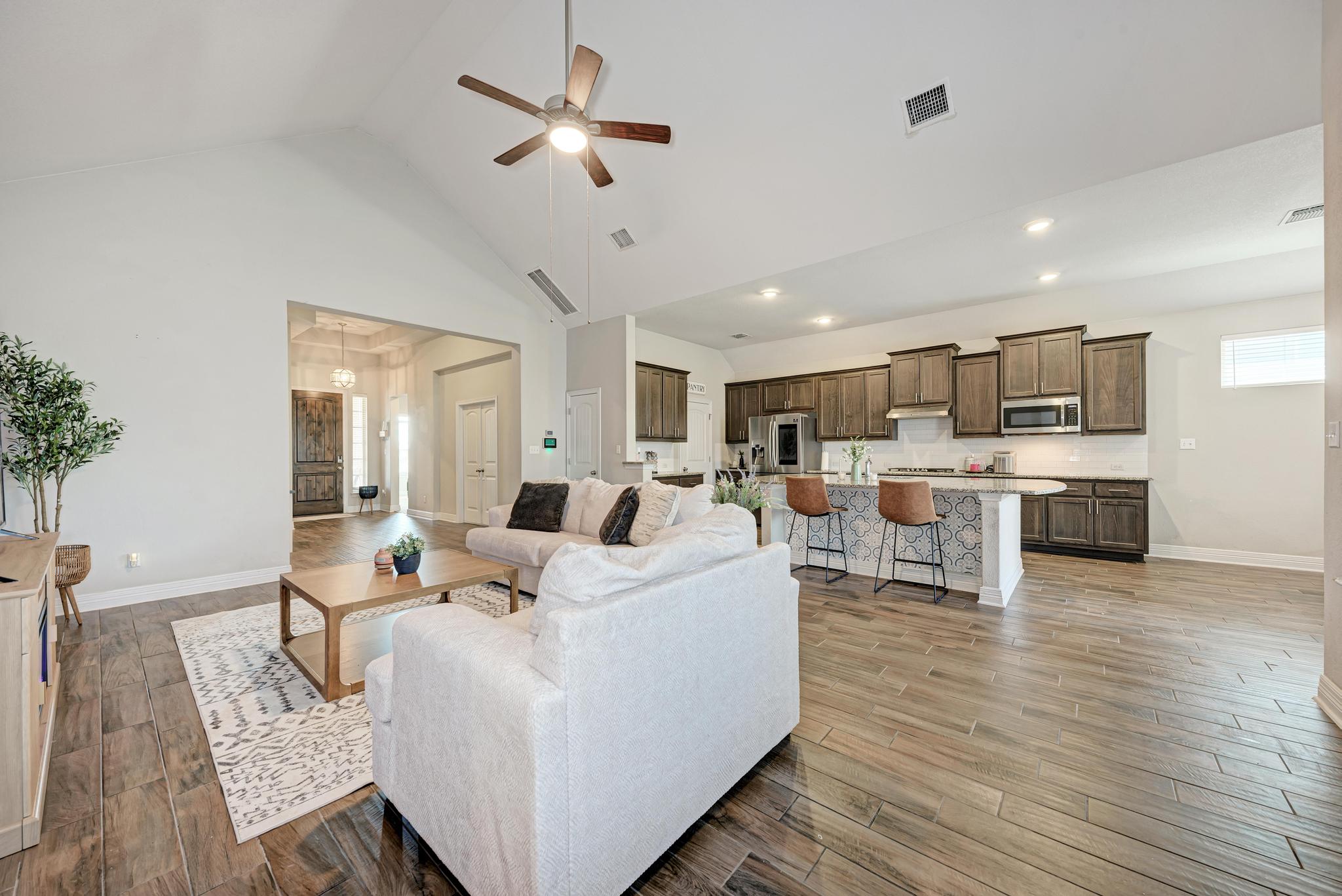 198 Rough Leaf Drive Buda, TX 78610 - Photo 9 of 38 Living room with ceiling fan, light wood-style floors, and vaulted ceiling