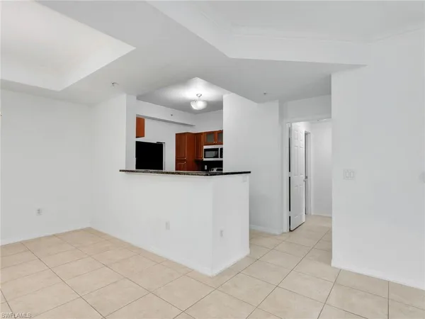 an empty room with wooden floor chandelier fan and windows