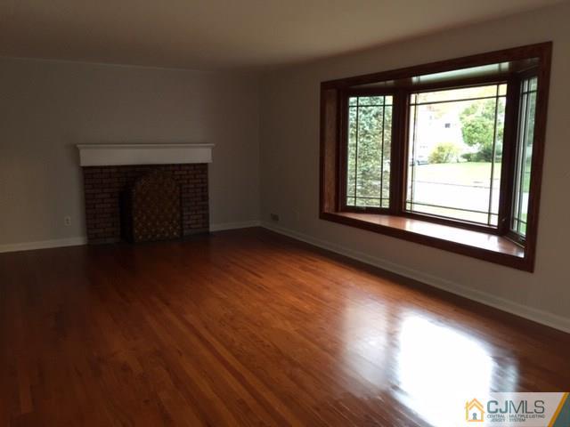 24 Clive Hills Road Edison, NJ 08820 - Photo 4 of 6 a view of an empty room with wooden floor and a window
