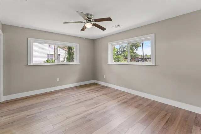 a view of room with window ceiling fan and hardwood floor