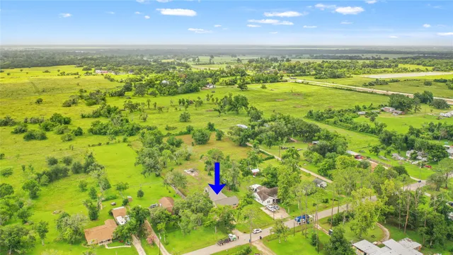 an aerial view of a house with a yard and trees