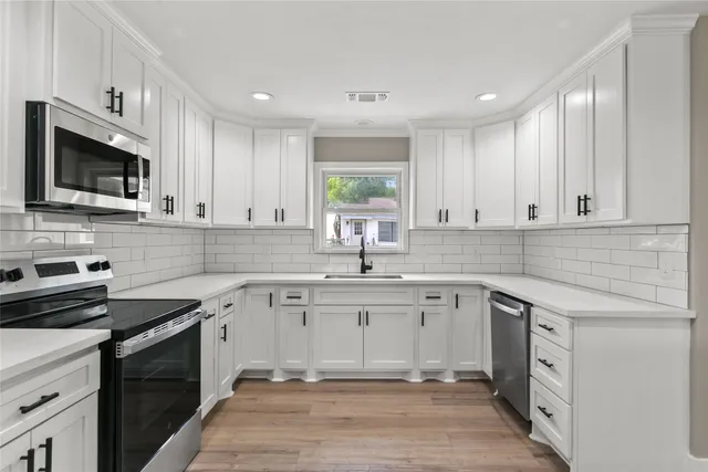 a kitchen with a sink stove and cabinets