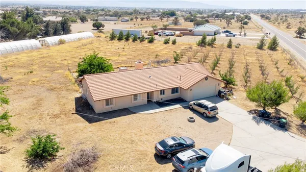 an aerial view of a house with yard and seating space