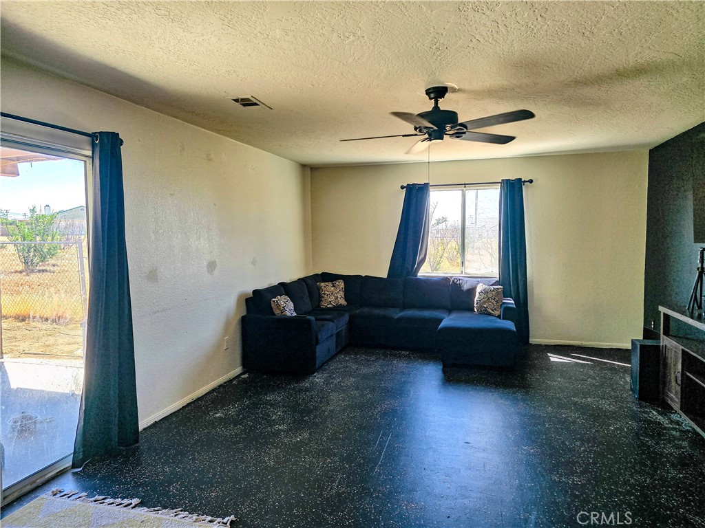 9995 Smoke Tree Road Hesperia, CA 92344 - Photo 23 of 74 a living room with couches and a flat screen tv with kitchen view