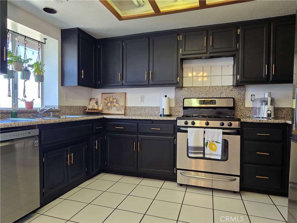 9995 Smoke Tree Road Hesperia, CA 92344 - Photo 30 of 74 a kitchen with a sink and a stove