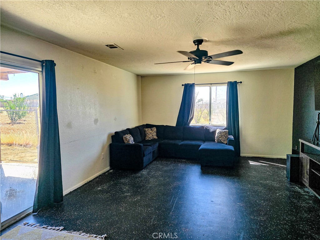 9995 Smoke Tree Road Hesperia, CA 92344 - Photo 38 of 74 a living room with couches and a flat screen tv with kitchen view