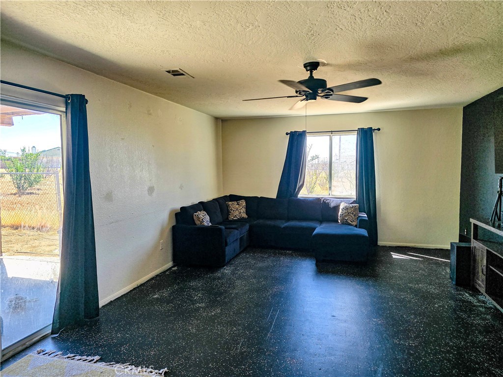 9995 Smoke Tree Road Hesperia, CA 92344 - Photo 56 of 74 a living room with couches and a flat screen tv with kitchen view