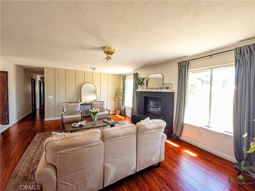 9995 Smoke Tree Road Hesperia, CA 92344 - Photo 58 of 74 a living room with furniture fireplace and wooden floor