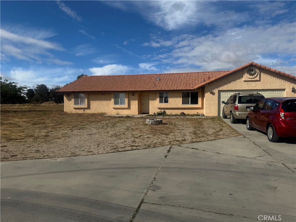 9995 Smoke Tree Road Hesperia, CA 92344 - Photo 72 of 74 a front view of a house with a garden and parking