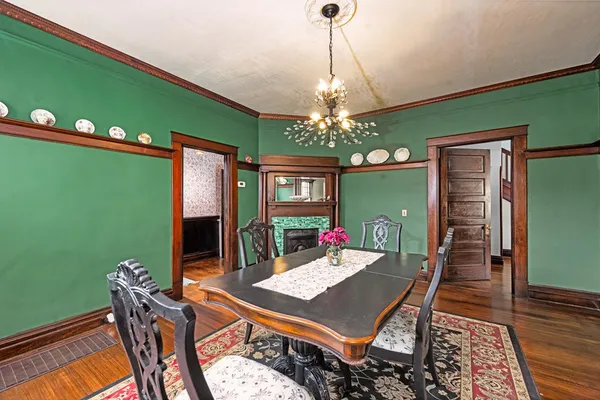 a view of a dining room with furniture a chandelier and wooden floor
