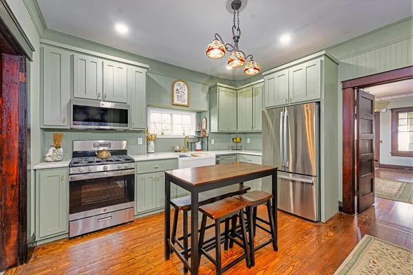 a kitchen with a stove a refrigerator and a dining table