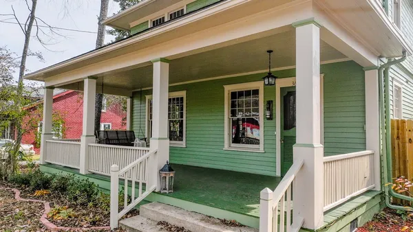 a view of a house with large windows and a small yard