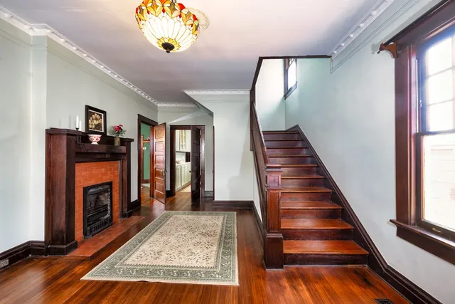 a view of an entryway with wooden floor a fire place